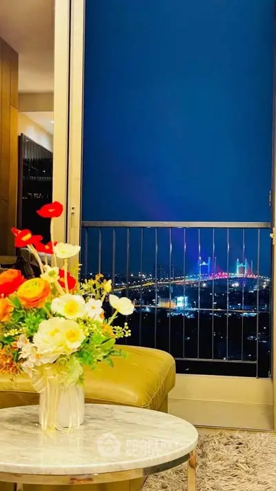 Stunning city view from a luxurious apartment balcony with vibrant night lights.