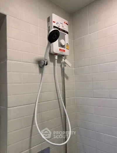 Modern bathroom with sleek showerhead and tiled wall, perfect for a refreshing experience.