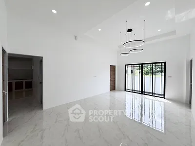 Spacious modern living room with elegant lighting and large windows offering natural light.