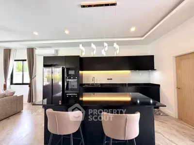 Modern kitchen with sleek black countertops and stylish lighting in open layout design