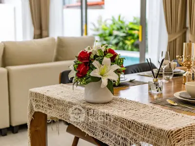Elegant dining area with floral centerpiece and pool view, perfect for entertaining in style.