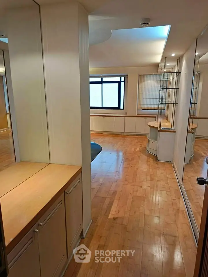 Spacious room with wooden flooring and ample natural light