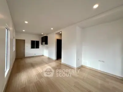 Spacious and bright living room with modern wooden flooring and recessed lighting.