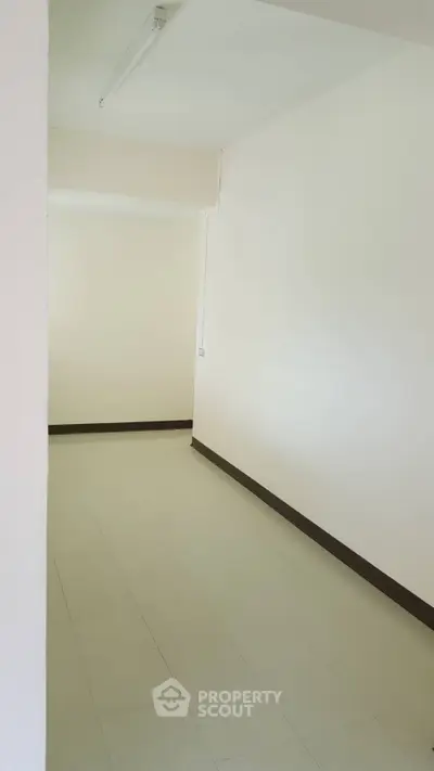 Spacious empty room with white walls and tiled floor, ideal for customization.