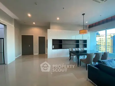 Spacious modern living room with dining area and large windows offering natural light.