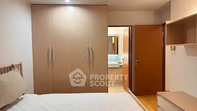 Cozy bedroom with modern wardrobe and ensuite bathroom in a stylish apartment.