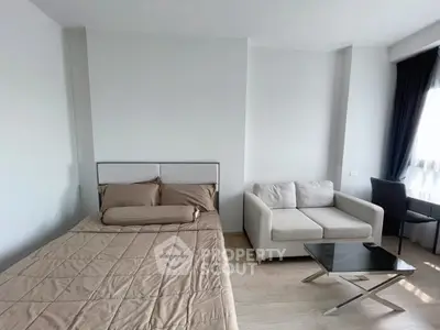 Modern bedroom with cozy bed and stylish sofa in a bright apartment