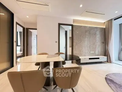 Modern dining area with elegant marble table and stylish chairs in a bright open-plan living space.