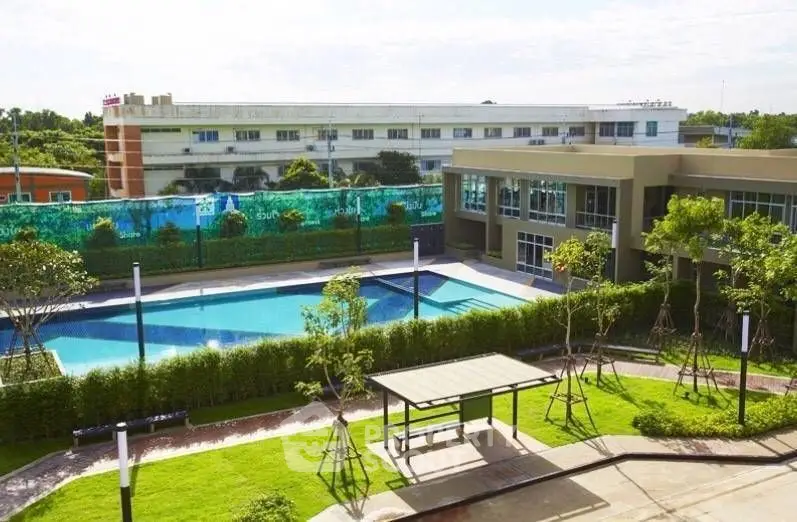 Luxurious residential complex with a stunning outdoor pool and lush greenery.