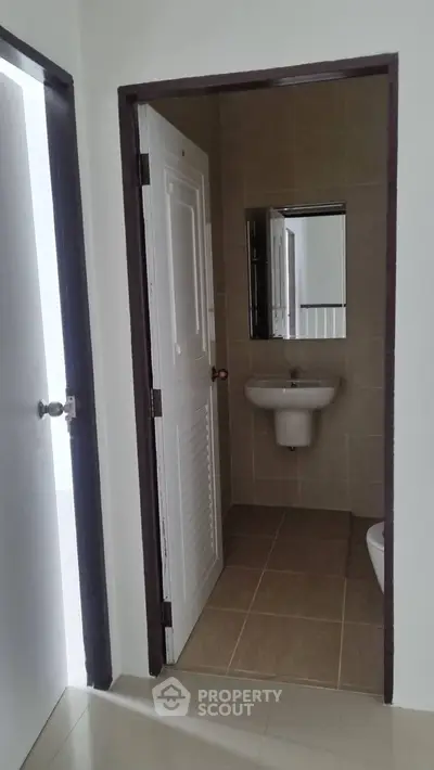 Compact bathroom with sink and mirror in modern apartment