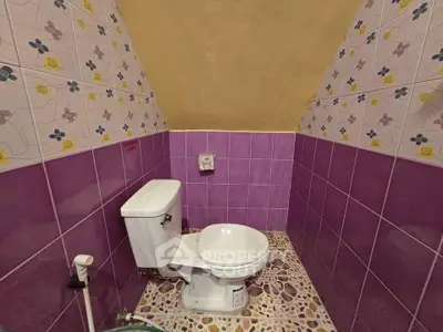 Charming bathroom with vibrant purple tiles and unique floral wall design.
