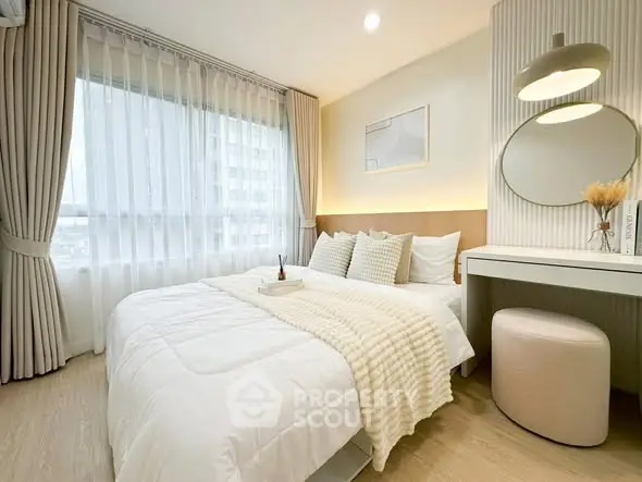 Elegant bedroom with modern decor, large window, and cozy ambiance in a stylish apartment.