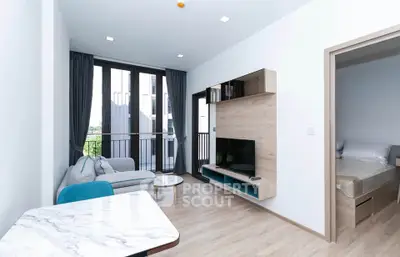 Modern living room with balcony access and stylish furniture in a bright apartment.