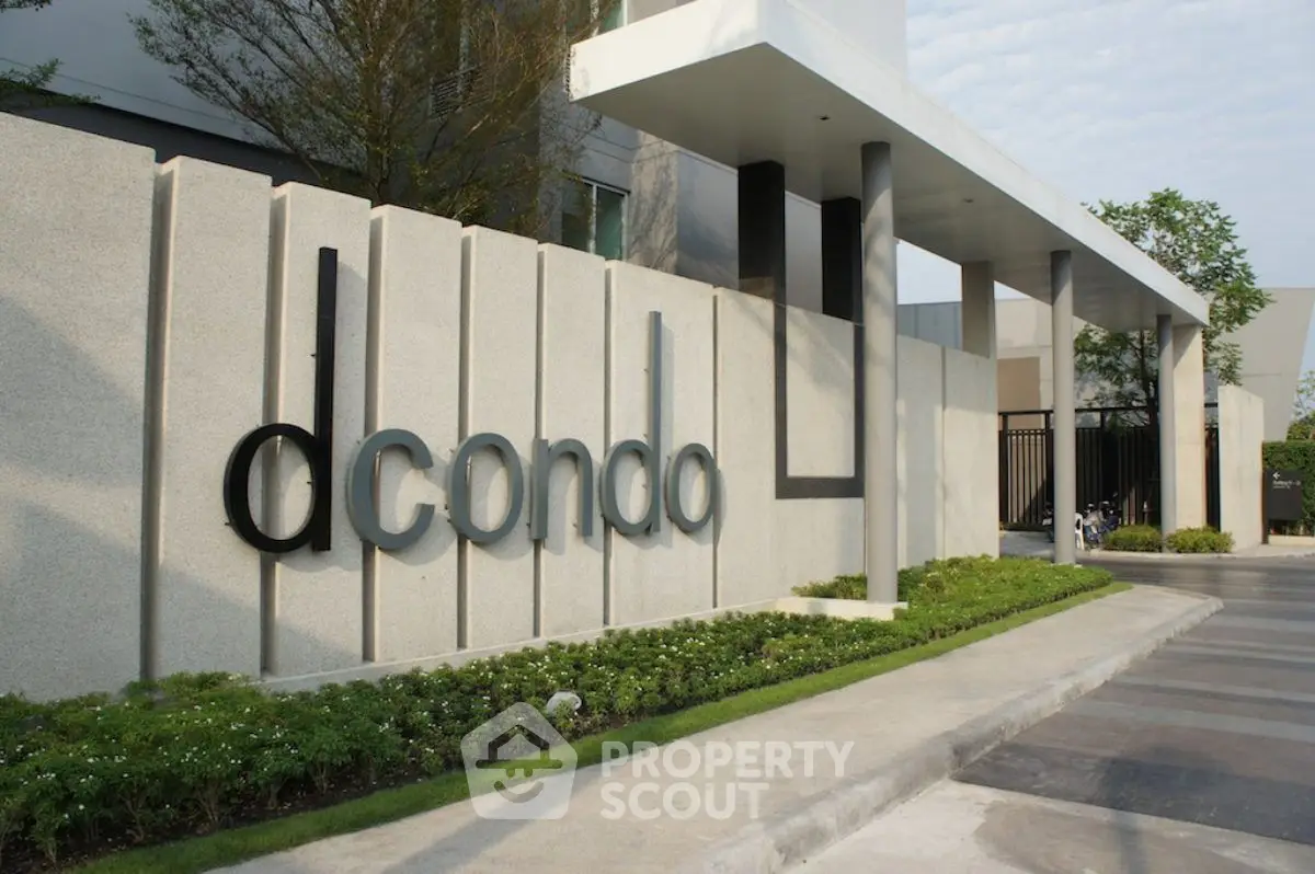 Modern condo entrance with sleek design and lush landscaping.
