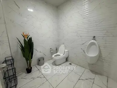 Spacious modern bathroom with marble tiles and elegant fixtures