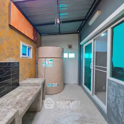Modern utility area with water tank and concrete bench in a contemporary home.
