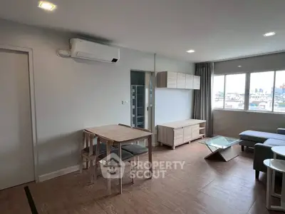 Modern living room with city view, featuring sleek furniture and natural light.