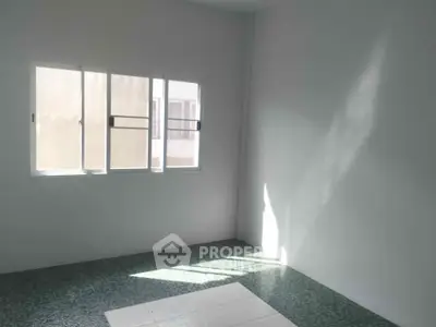 Bright empty room with large window and tiled floor, perfect for customization.