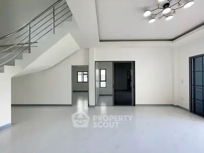 Spacious modern living room with sleek staircase and stylish lighting