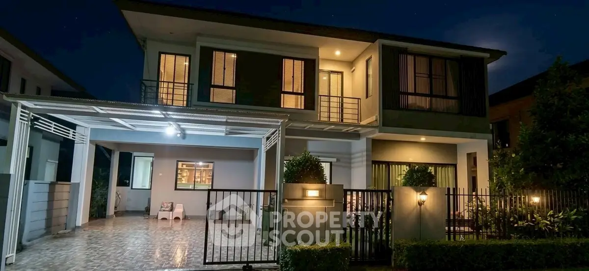 Stunning two-story modern home with spacious driveway and elegant night lighting.