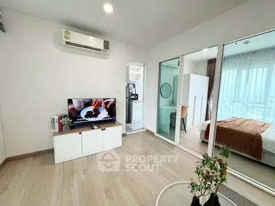 Modern living room with TV, air conditioning, and view into bedroom with natural light.
