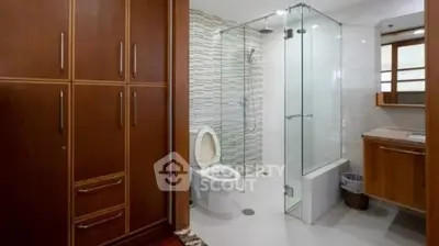 Modern bathroom with glass shower and wooden cabinetry