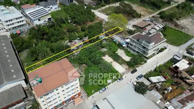 Aerial view of a residential area with a highlighted plot of land for development.