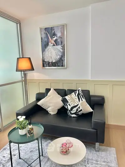 Chic living room with modern black sofa and elegant decor, perfect for urban living.