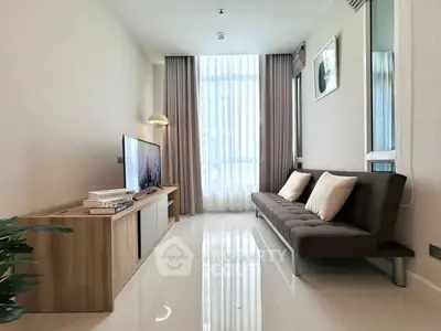 Modern living room with sleek furniture and large window, perfect for relaxation.