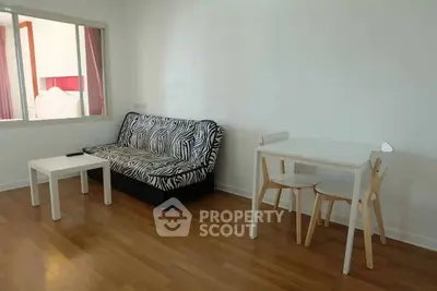 Modern living room with zebra-patterned sofa and minimalist dining set on wooden flooring.