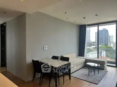 Modern living room with city view, featuring sleek furniture and large windows for natural light.