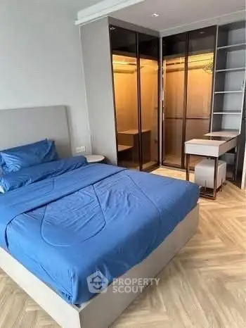 Modern bedroom with blue bedding and stylish wardrobe in a chic apartment.