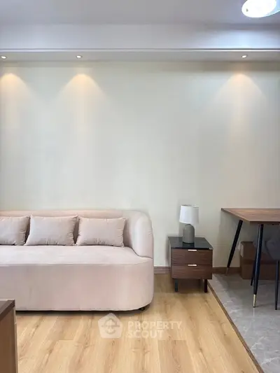 Modern living room with beige sofa, wooden flooring, and stylish furniture.