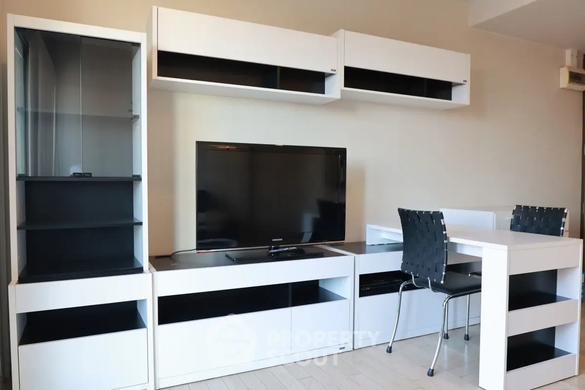Modern living room with sleek white furniture and flat-screen TV, perfect for contemporary living.