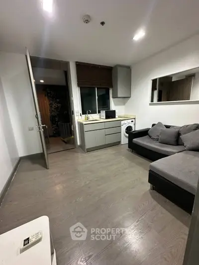 Modern living room with sleek furniture and integrated kitchen appliances