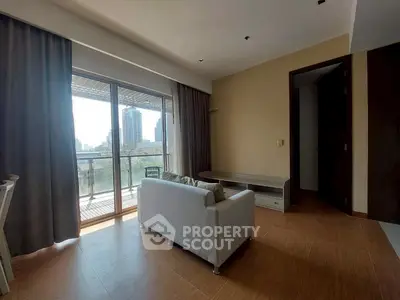 Spacious living room with large balcony and city view, perfect for urban living.
