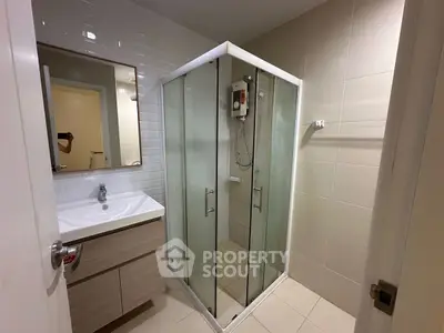 Modern bathroom with glass shower and sleek vanity in a contemporary apartment.