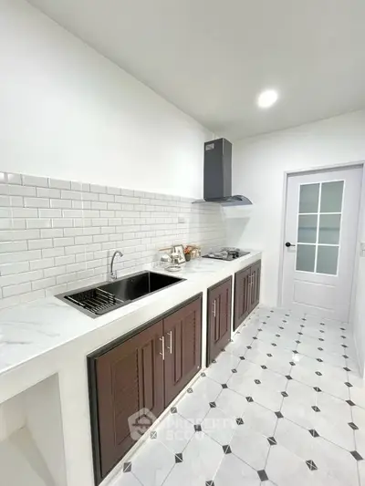 Modern kitchen with sleek white cabinets and stylish backsplash in a contemporary home.