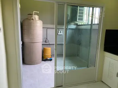 Utility room with water tank and sliding glass door in modern home