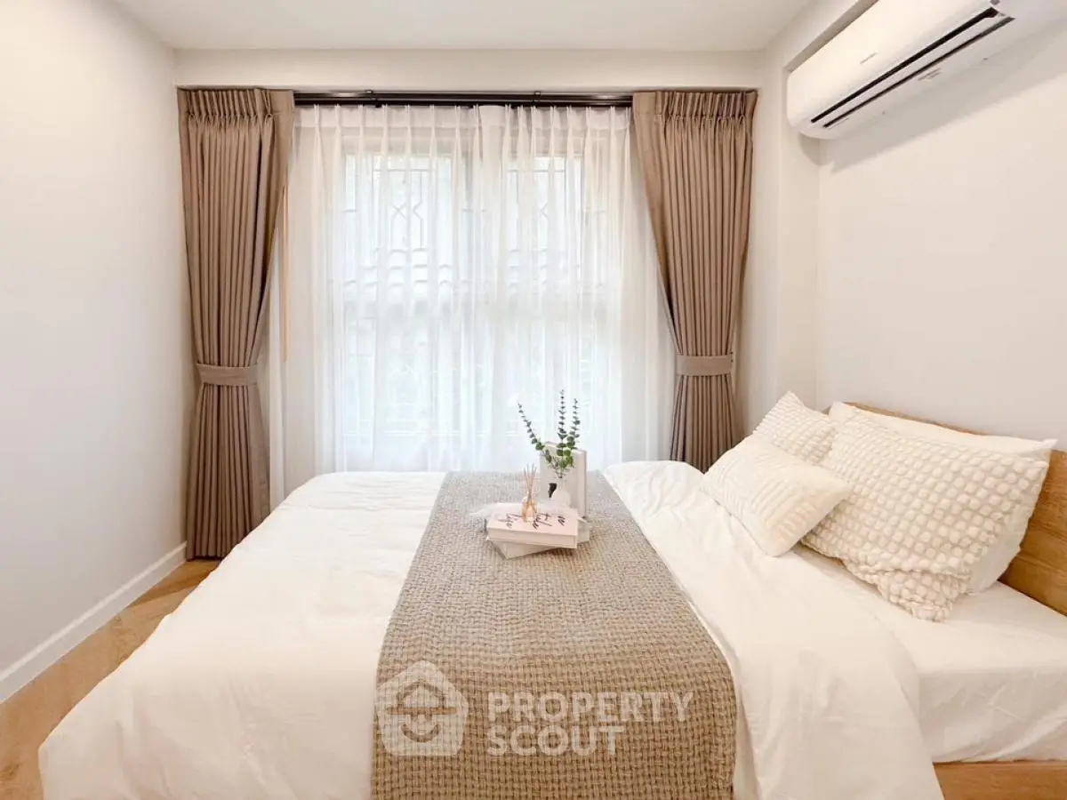 Cozy bedroom with elegant curtains and air conditioning, perfect for relaxation.
