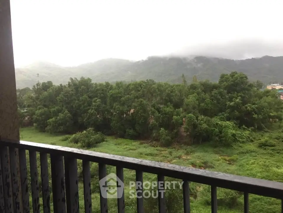 Scenic balcony view overlooking lush green landscape and distant hills, perfect for nature lovers.