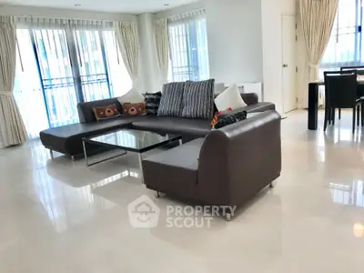 Spacious modern living room with elegant sofa and large windows in a luxurious apartment.
