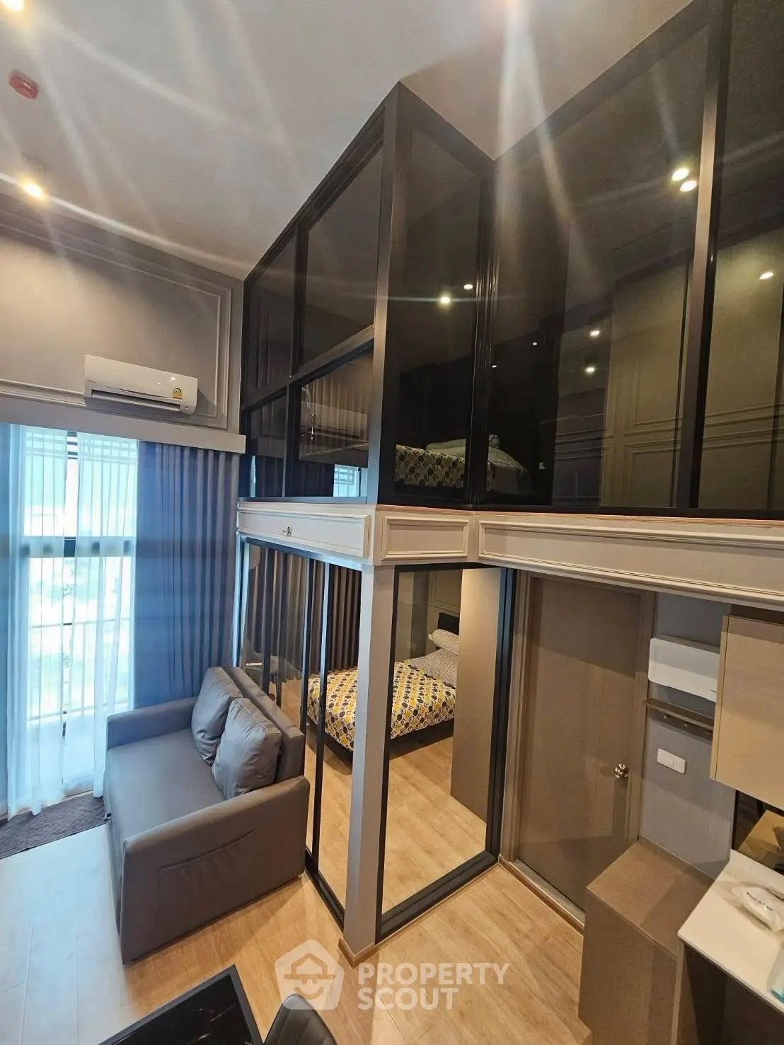 Modern loft-style living room with mezzanine bedroom and large windows