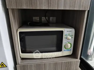 Compact kitchen microwave in modern wooden cabinet