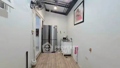 Compact kitchen with stainless steel fridge and minimalist design