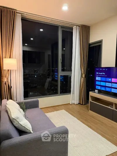 Modern living room with city view, cozy sofa, and smart TV setup.