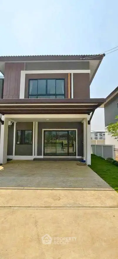 Modern two-story house with large windows and driveway in a suburban neighborhood.