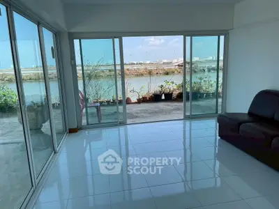 Spacious living room with stunning water view and large glass doors.