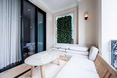 Elegant balcony with modern seating and lush greenery, perfect for relaxation and entertaining.