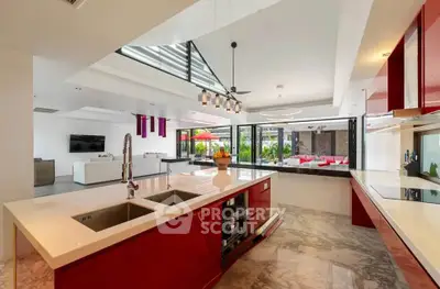 Luxurious open-layout kitchen with modern red cabinetry and spacious island